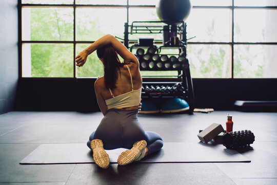 Young athletic woman in deep pigeon pose engages hip mobility and recovery, supported by smart fitness routine, AI-guided form corrections and connected flexibility tools.