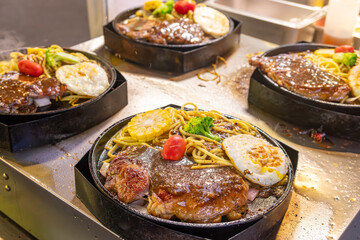 four freshly cooked steak spaghetti with fried eggs
