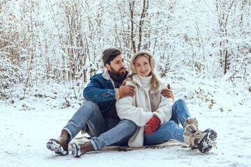 Obraz premium Happy young couple in the winter forest feeling excited and enjoyed