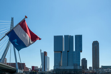 Rotterdam city modern architecture towers and Erasmus bridge, dutch flag waving, Netherlands