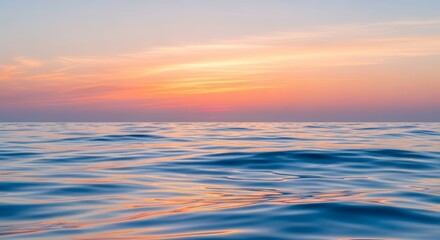 Obraz premium Serene ocean waves reflect a vibrant sunset sky, creating a peaceful natural landscape.