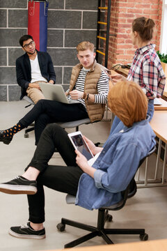 Collective thinking. Group of young creative startuppers putting their heads together and developing new business strategies while having meeting in office