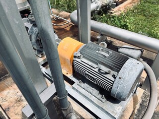Industrial centrifugal pumps and electric motors installed on concrete floor, connected to...