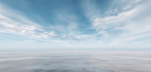 The serene ocean horizon under a beautiful blue sky with soft clouds.