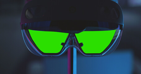 Close-up of futuristic VR AR headset with glowing neon edges and bright green chroma key lenses, perfect for technology presentations, mixed reality concepts, and high-tech promotional visuals.