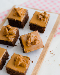 Gourmet Biscoff Brownies on a Wooden Board, Chocolate Brownies with a Smooth Cookie Butter Topping, The image highlights the combination of classic chocolate and a popular, modern flavor, making 