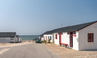 Stenbjerg, North Jutland, Denmark. Classic white fishing huts, sandy beaches, and scenic dunes at the North Sea coastline in Thy National Park, an iconic Danish fishing village setting.
