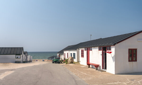 Stenbjerg, North Jutland, Denmark. Classic white fishing huts, sandy beaches, and scenic dunes at the North Sea coastline in Thy National Park, an iconic Danish fishing village setting.