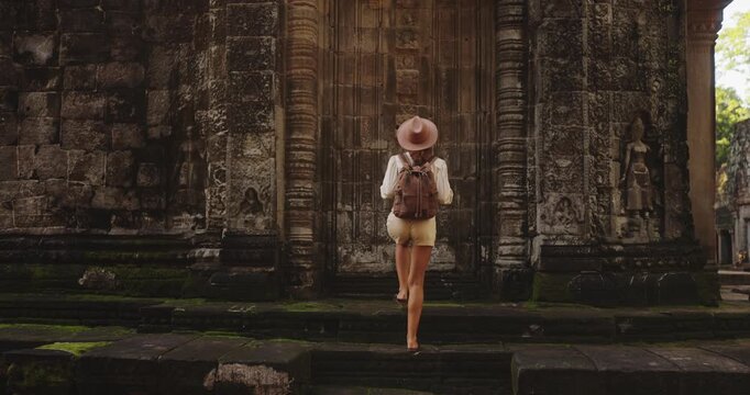 Traveler Woman Walking Toward Ancient Temple And Touching Stone Walls