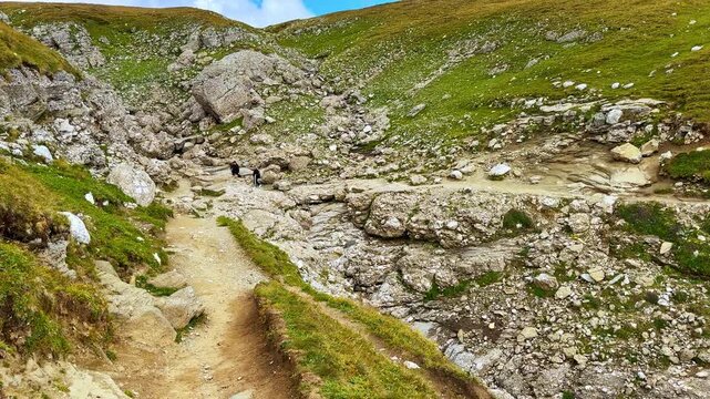 Walking by the trails in the Bucegi Mountains. Meeting two tourists hiking by the rocks. Southern Carpathians, Romania.