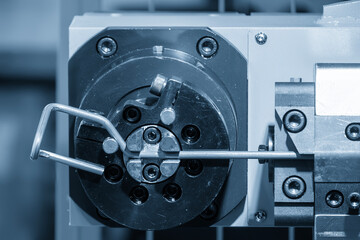 Obraz na płótnie Canvas The steel wire forming machine in the light blue scene.