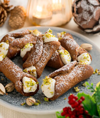 Sicilian cannoli filled with ricotta cheese cream and topped with chopped pistachios.