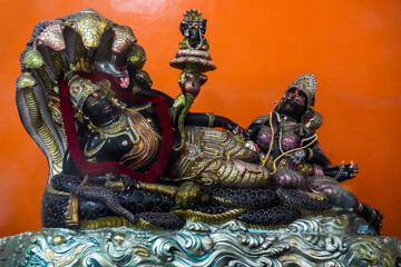 Fototapeta premium Lord Vishnu on Sheshnag Throne – Ornate Hindu Deity Statue with Jewelry and Garland