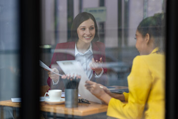 Businesswoman and multi-ethnic colleagues in the workplace are talking and discussing new business projects and collaborations.