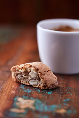 Cantuccini (Italian cookie) and a cup of coffee on dark wooden background. Close up.	