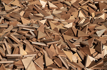 A pile of wood scraps left over from the production of oak parquet, woodworking waste creates an abstract texture