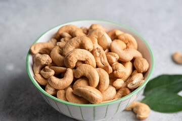 Closeup view group of roasted cashews in bowl, healthy vegan snack