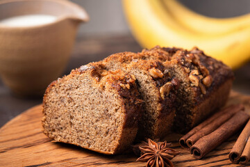 Whole wheat banana bread with walnuts and cinnamon on wooden cutting board
