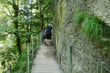 Wanderer im Wald im Allg&auml;u auf Steg am Eistobel