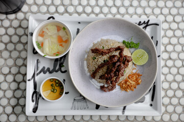 Paradise beef fried rice served with grilled beef slices, lime, parsley, and crispy shallots. Comes with clear soup and dipping sauce on the side. Top View