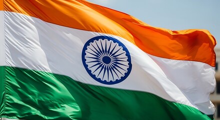 Waving Indian national flag with vibrant colors against a blue sky background