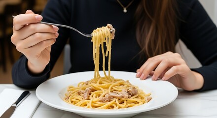 Woman enjoying a plate of delicious spaghetti carbonara at a restaurant