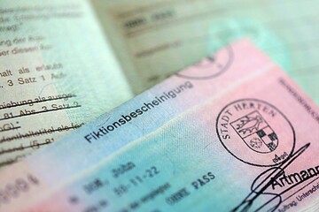 German temporary Permanent resident card lies on wooden table. Fiktionsbescheinigung