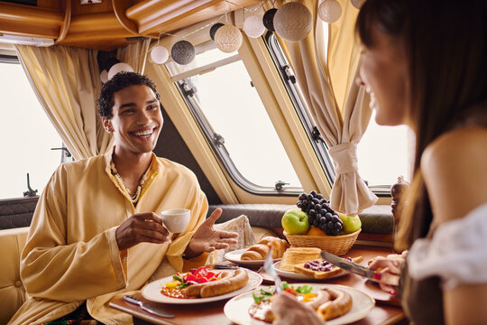 Young couple enjoys a romantic breakfast during camping adventure in a cozy glamping space