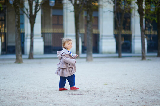 Adorable toddler girl walking in a park in Paris, France