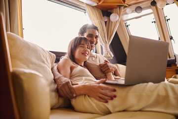 Young couple enjoying a cozy moment while glamping in their stylish campervan