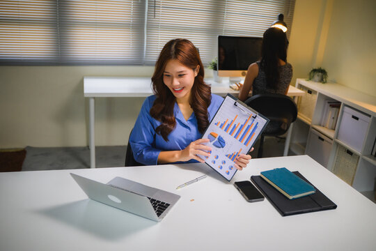 Asian businesswoman showing financial charts during video call, having online business meeting in modern office