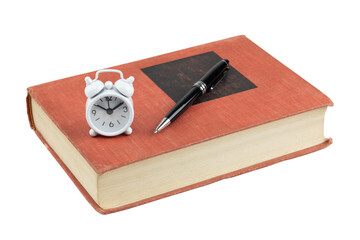 Vintage red book with a black pen and a small white alarm clock. Concept of study deadline, time management, and education, isolated on white background with clipping path.