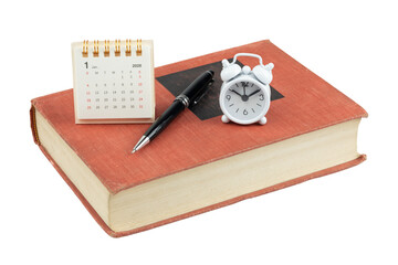 Desk calendar for January 2026 with an alarm clock, pen, and old book. Concept of new year resolutions, planning, scheduling, and time management isolated on white background with clipping path.