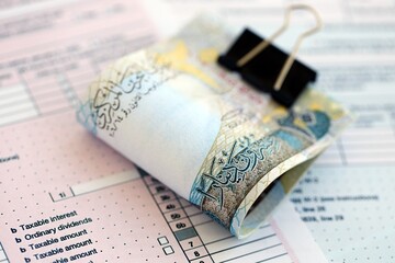 Bahraini dinar money bills on tax form. Taxation and accounting concept