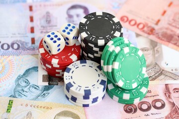 Thai baht currency money bills and casino chips with dice. The concept of gambling and casino