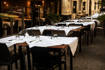 Empty tables set at a cafe awaiting tourists in Catania. Traveling in Sicily