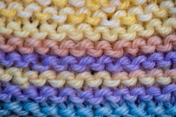 background close up of hand knitting in garter stitch colourful wool 