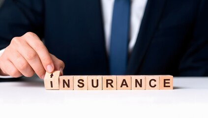 Obraz premium Businessman Arranging Wooden Blocks with Insurance Word on Table