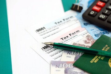 Nigerian naira money bills and calculator with tax form on flag close up. Taxation and accounting...