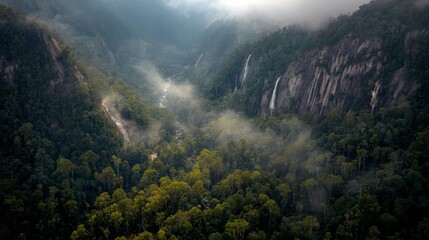 Tropical mountain jungle with waterfalls cascading down cliffs in misty atmosphere, high-resolution exotic wilderness landscape scene