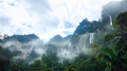 Tropical mountain jungle with waterfalls cascading down cliffs in misty atmosphere, high-resolution exotic wilderness landscape scene