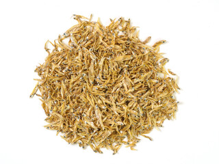 Top view of pile of dried small fish, golden-brown in color, arranged on white background