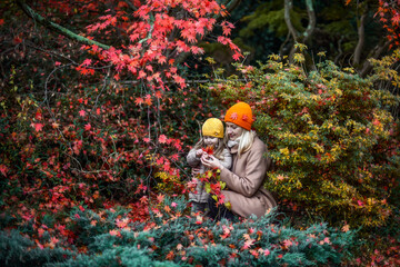 Mother and daughter in autumn in a beautiful park