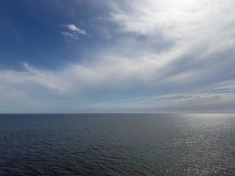 Calm sparkling sea and beautiful sky clouds .