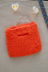 Handmade knitted orange bag on a light background