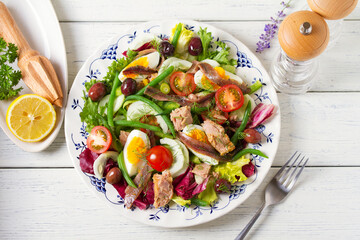 Mediterranean Tuna Salad. Nicoise Salad. White wooden background. High angle view