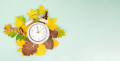 Winter time changeover, end of daylight saving time in autumn, alarm clock fall back switch, colorful foliage, change season