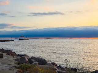 A Beautiful and Serene Sunset Over the Calm Waters with a Peaceful Boat Gently Floating Along