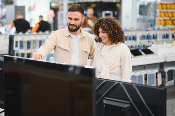 Couple choosing television in electronics store