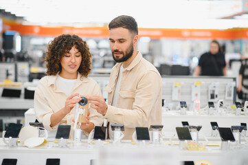 Couple choosing security camera in electronics store